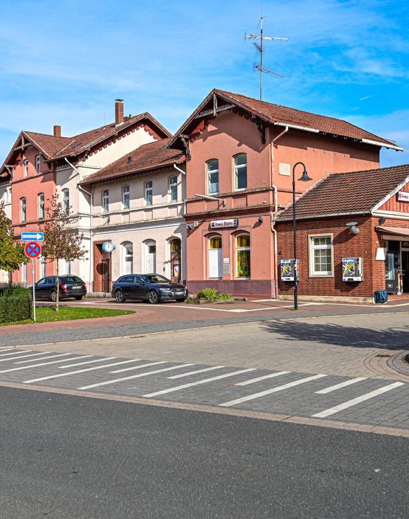 Das Bahnhofsgebäude in Walsrode in einer Frontalansicht mit Sicht auf den Bahnhofsvorplatz